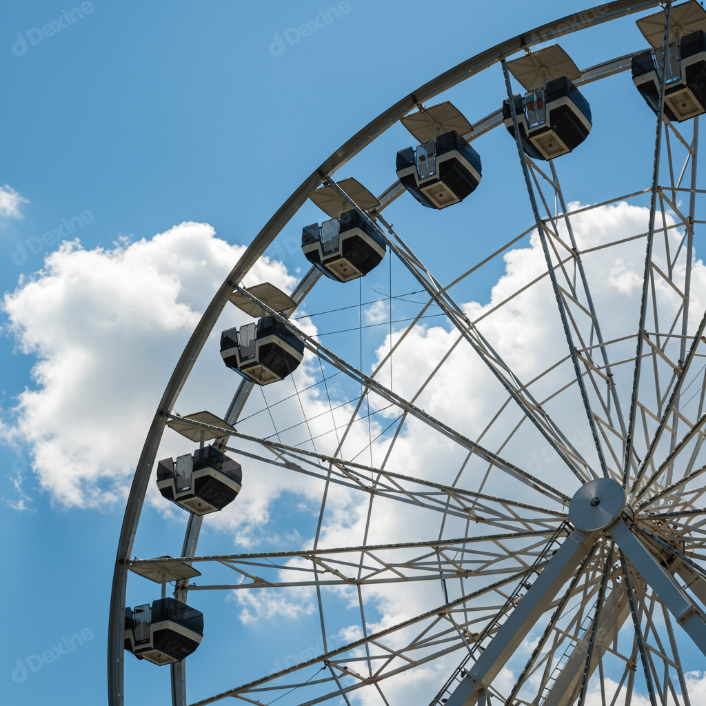 Iconic Ferris Wheel Against Blue Sky And White Clouds