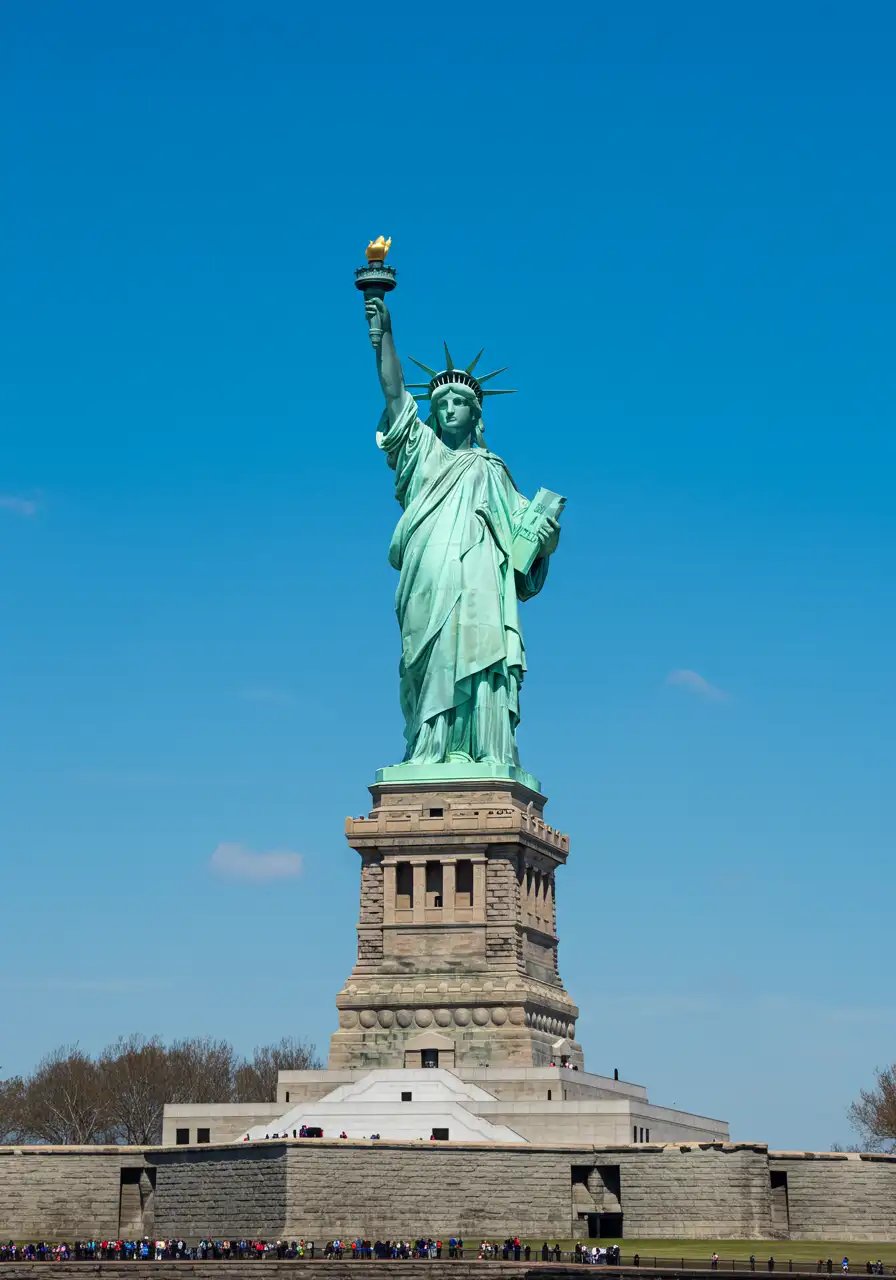 Iconic Statue Of Liberty Against Blue Sky In New York City