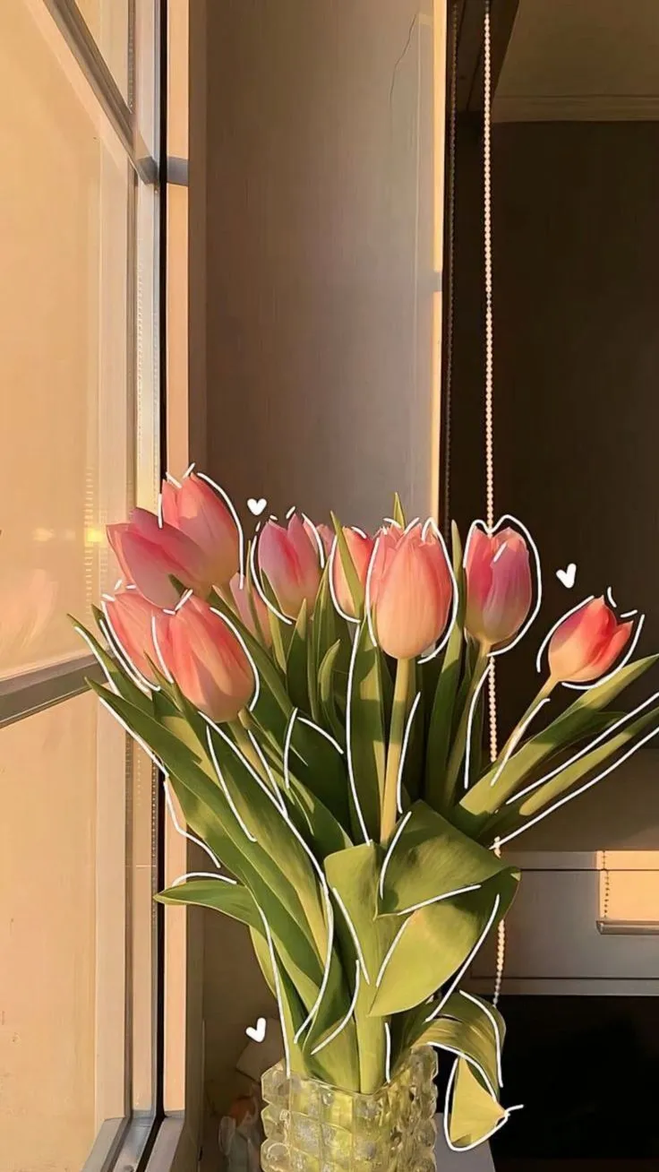 a vase filled with pink tulips sitting on top of a window sill