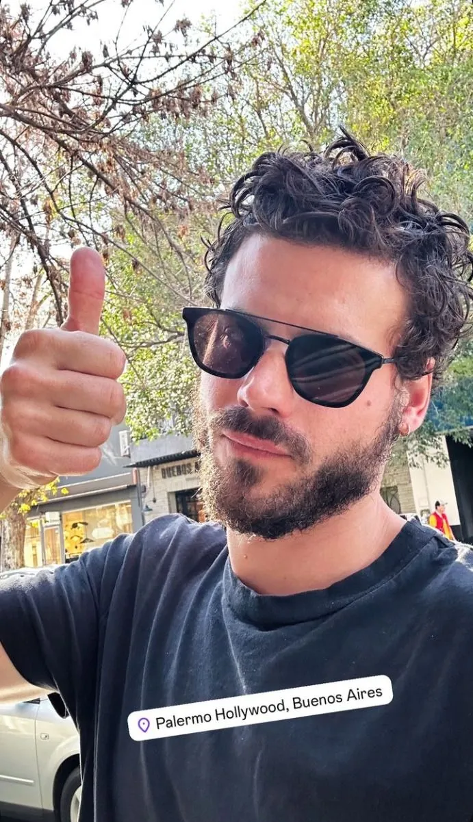 a man wearing sunglasses giving the thumbs up sign