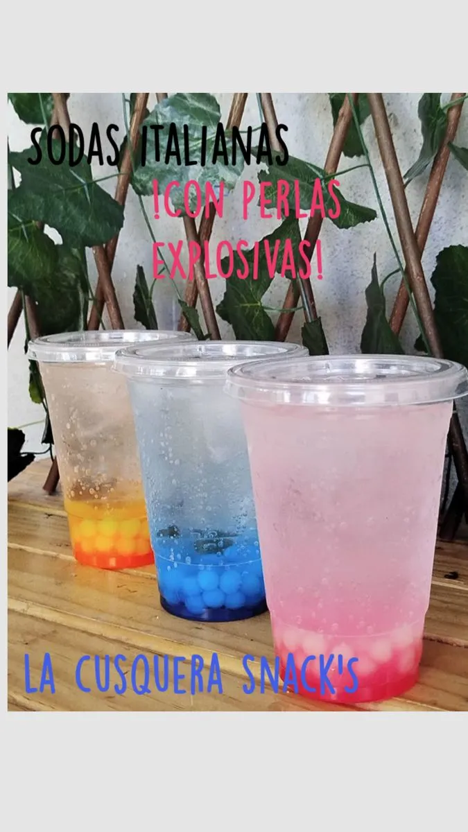 three different colored drinks sitting next to each other on top of a wooden table with plants in the background
