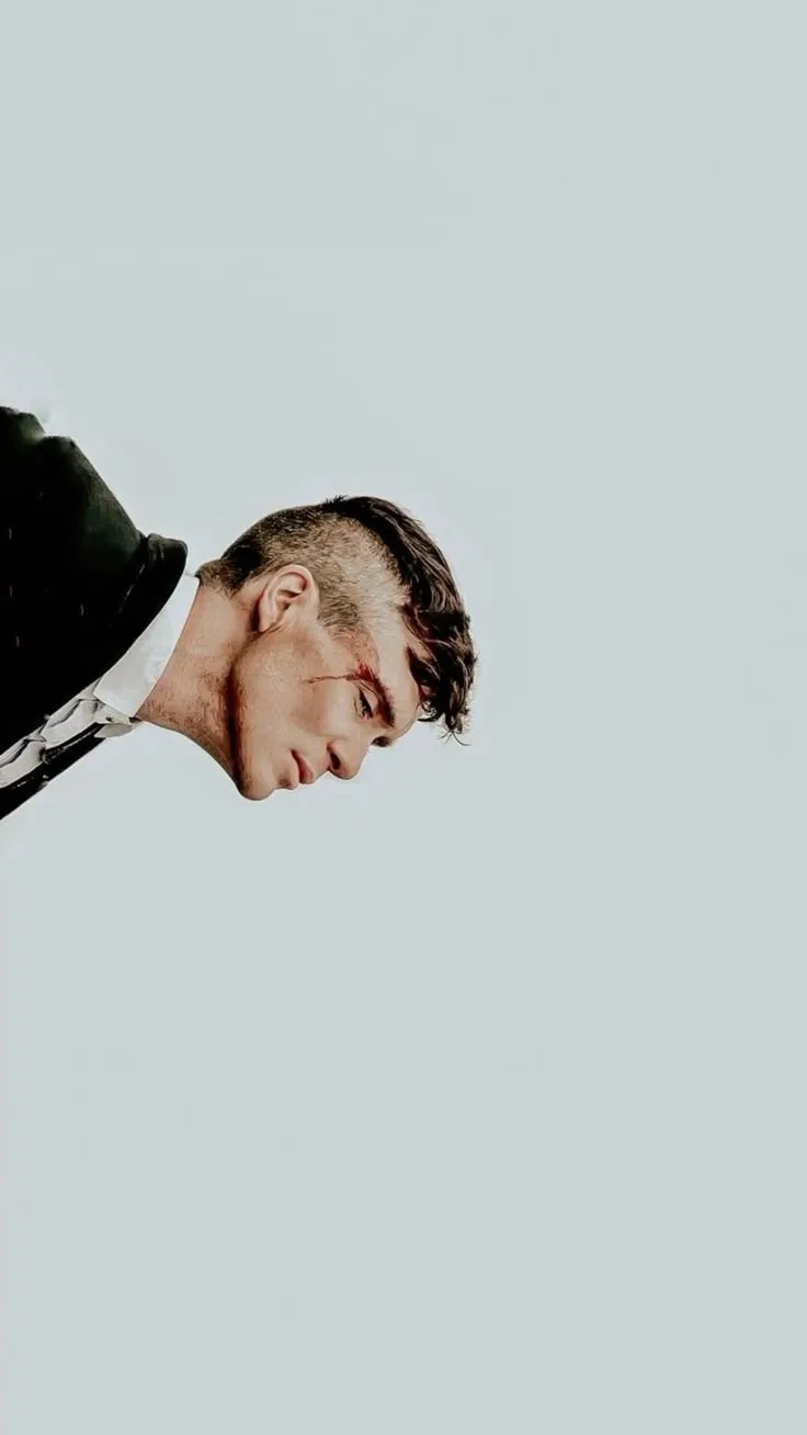 a man wearing a suit and tie looking down at something in the sky behind him