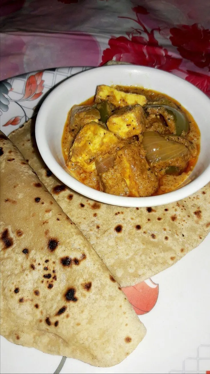 a bowl of food on a plate next to some tortilla chips and a napkin