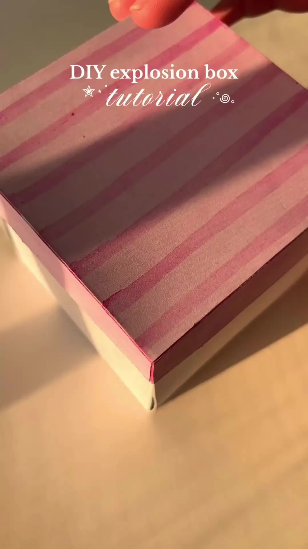 a person is holding a book with the title diy explosion box material on it