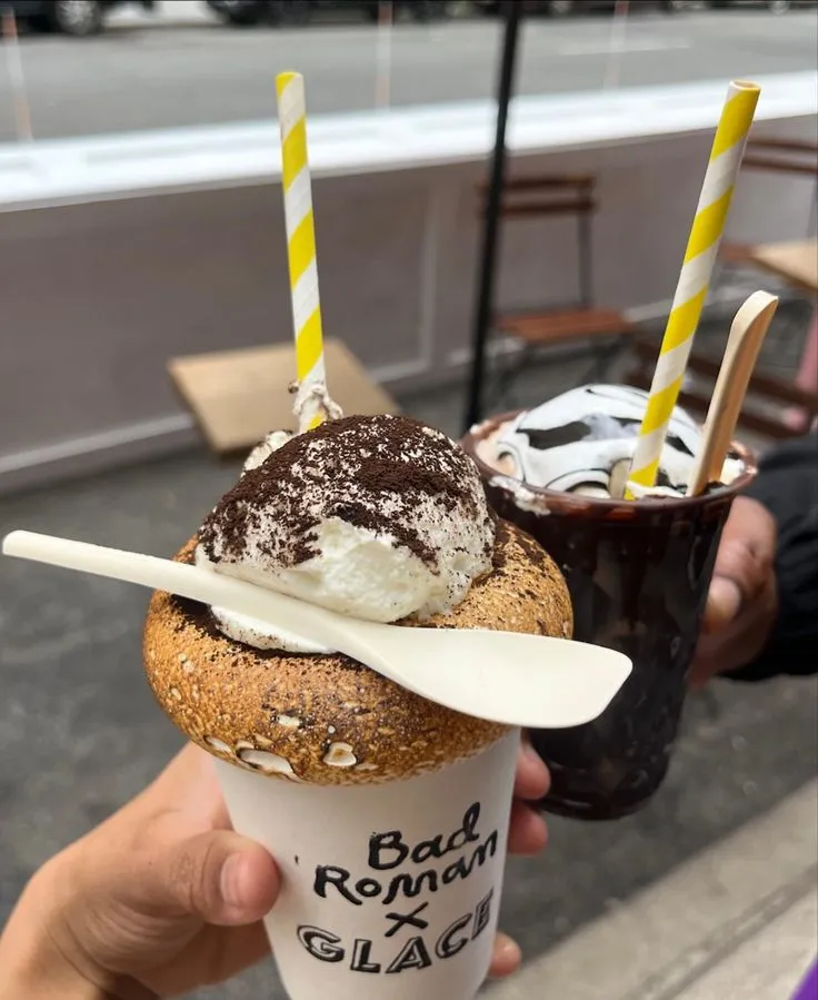 We got to stop by @glacenoglu and try the BAD ROMAN (Tiramasu Frozen Hot Chocolate) let me give yall the specs 👀🤫 Frozen layers of their hot chocolate and coffee CRUNCHY chocolate hardshell Whipped Cream Black Cacao Powder with a TOASTED marshmallow rim A
