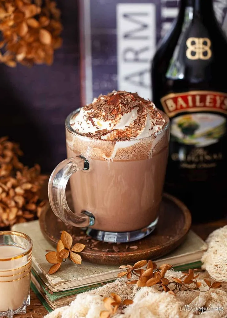 there is a hot chocolate drink with whipped cream in the cup and nuts around it