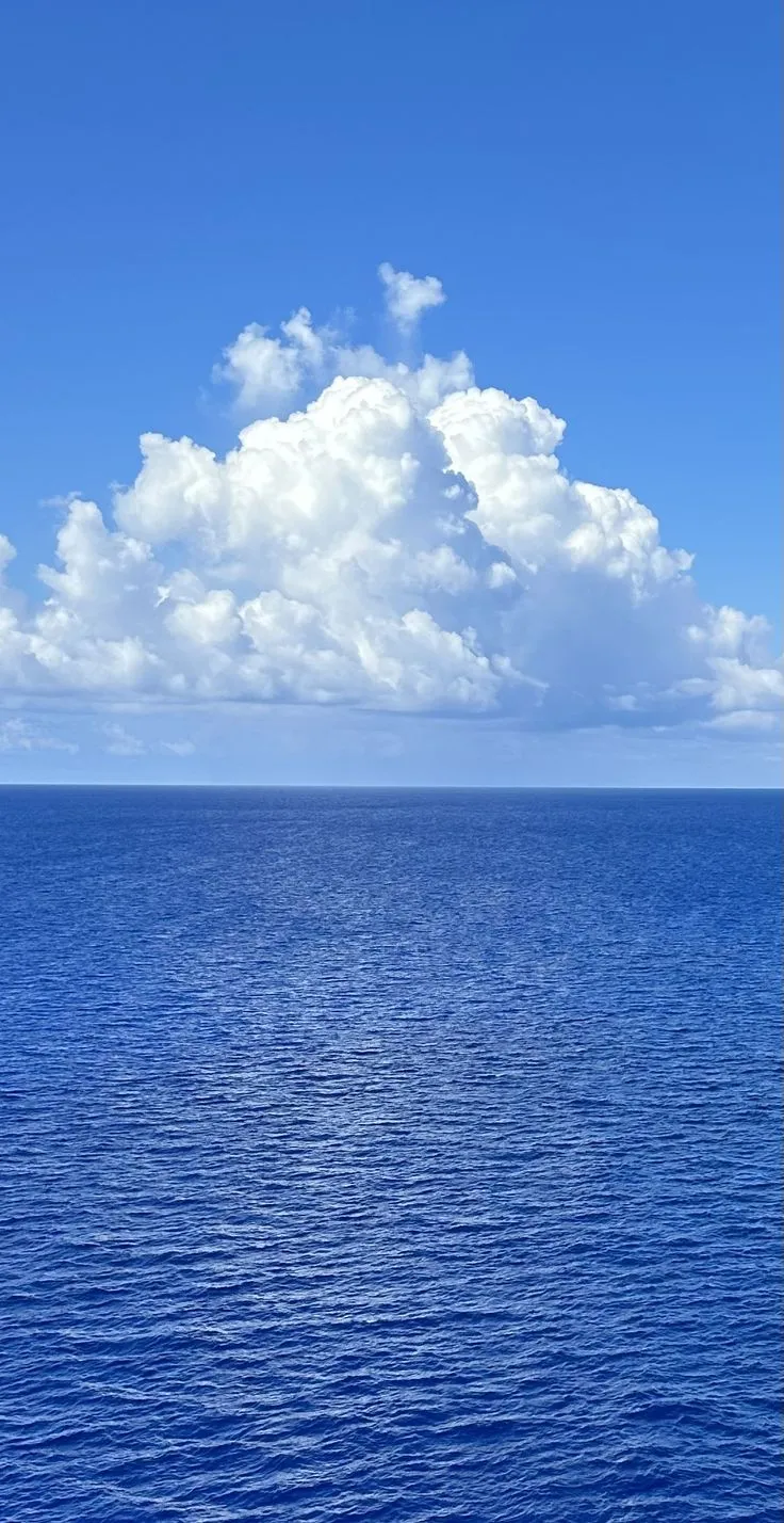 an ocean view with clouds in the sky and blue water on both sides that is almost empty