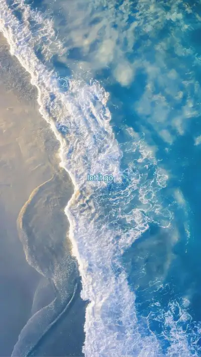 an aerial view of the ocean with waves coming in