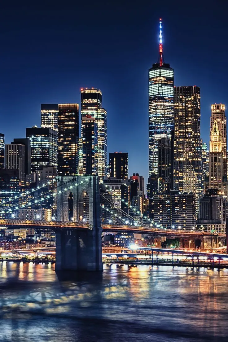 the city skyline is lit up at night, and it's lights shine brightly