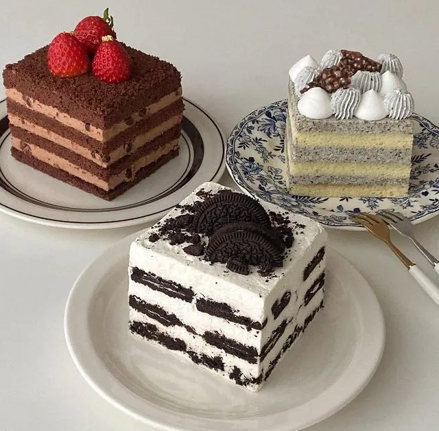 three different types of cakes on plates with forks and spoons next to each other