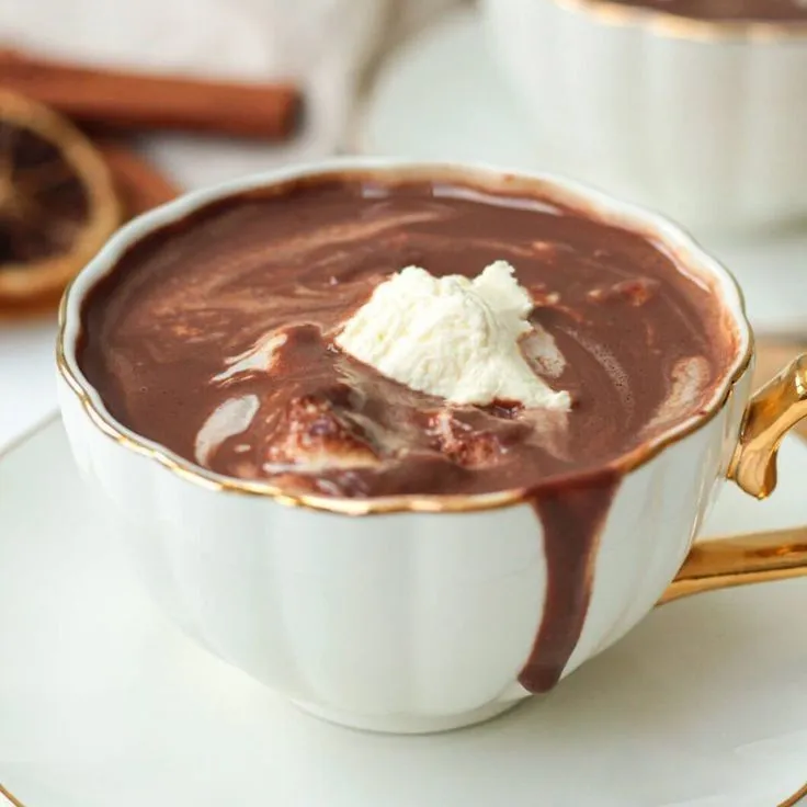 a white cup filled with chocolate and whipped cream