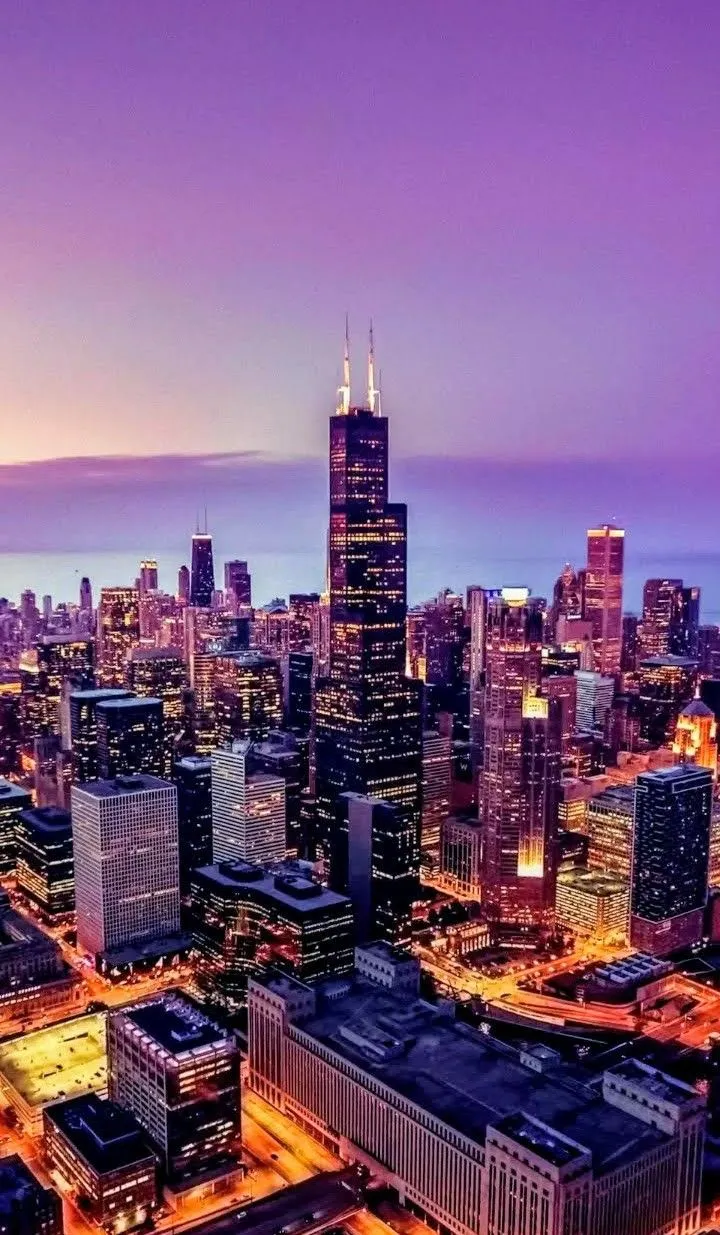 an aerial view of the chicago skyline at night, with skyscrapers in the foreground