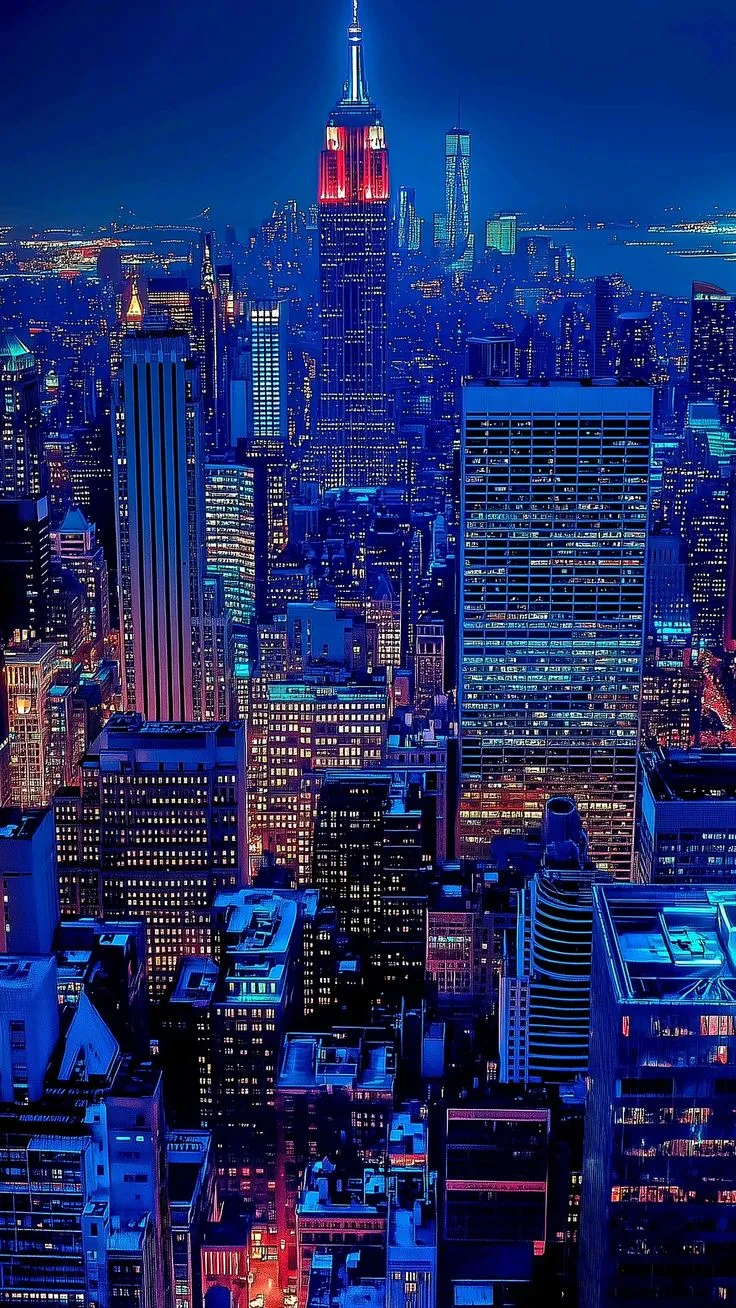 an aerial view of the city at night with skyscrapers lit up in red, white and blue