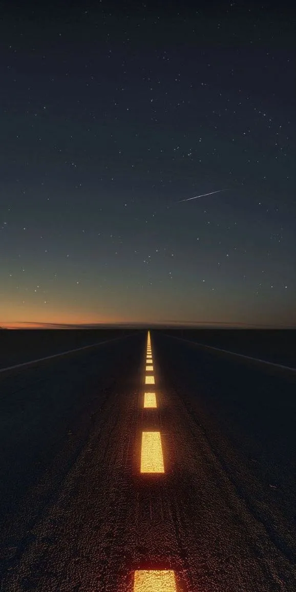 an empty road at night with stars in the sky and one light shining on it