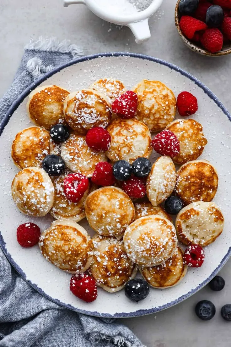 Poffertjes are small, fluffy Dutch pancakes that are so delicious for breakfast! Serve them with powdered sugar and fresh berries.