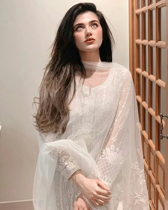 a woman with long hair wearing a white dress