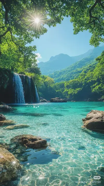 the sun shines brightly over a beautiful waterfall and clear blue water, surrounded by lush green mountains