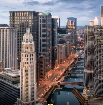 an aerial view of a city with skyscrapers and water in the foreground at dusk