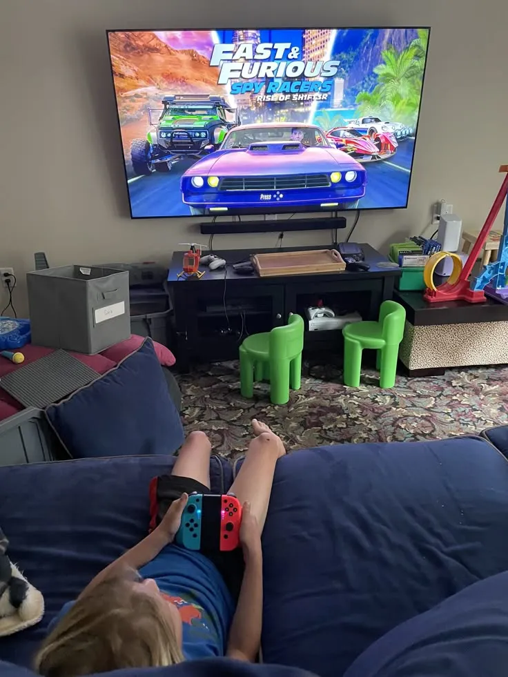 a person sitting on a couch playing a video game