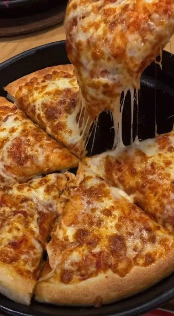 someone is taking a slice of cheese pizza