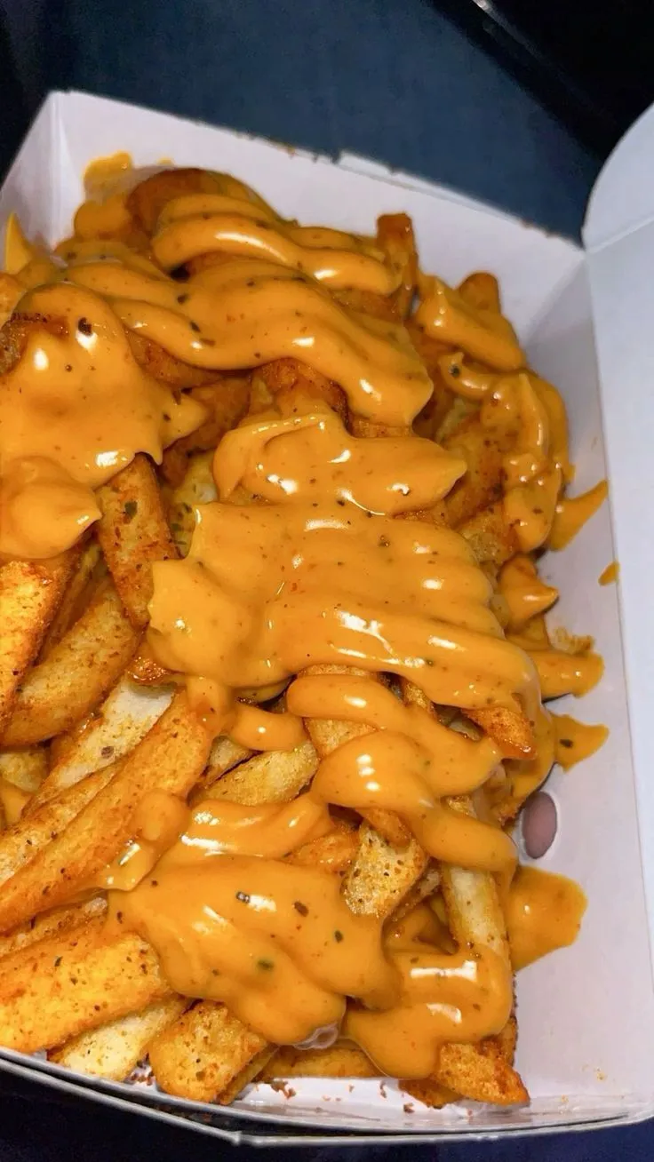 a box filled with french fries covered in cheese sauce