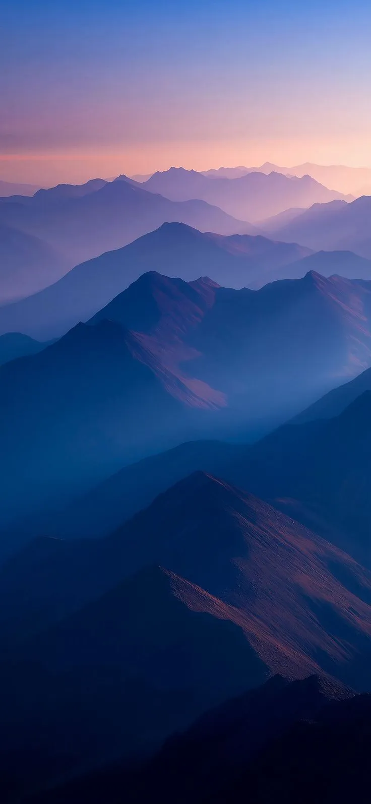 the mountains are covered in fog at sunset