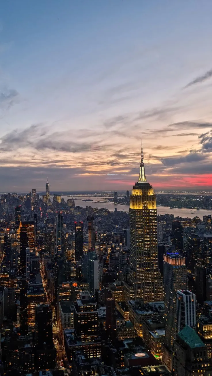 an aerial view of new york city at night with the empire building in the foreground