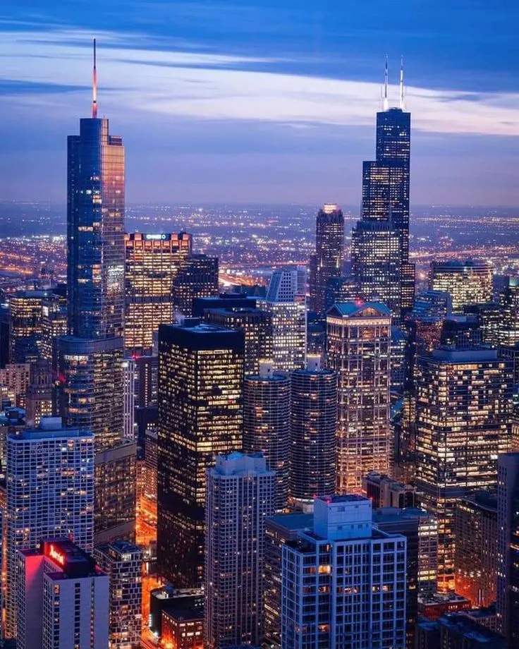 the city lights shine brightly at night in this aerial view from above, with skyscrapers and other tall buildings